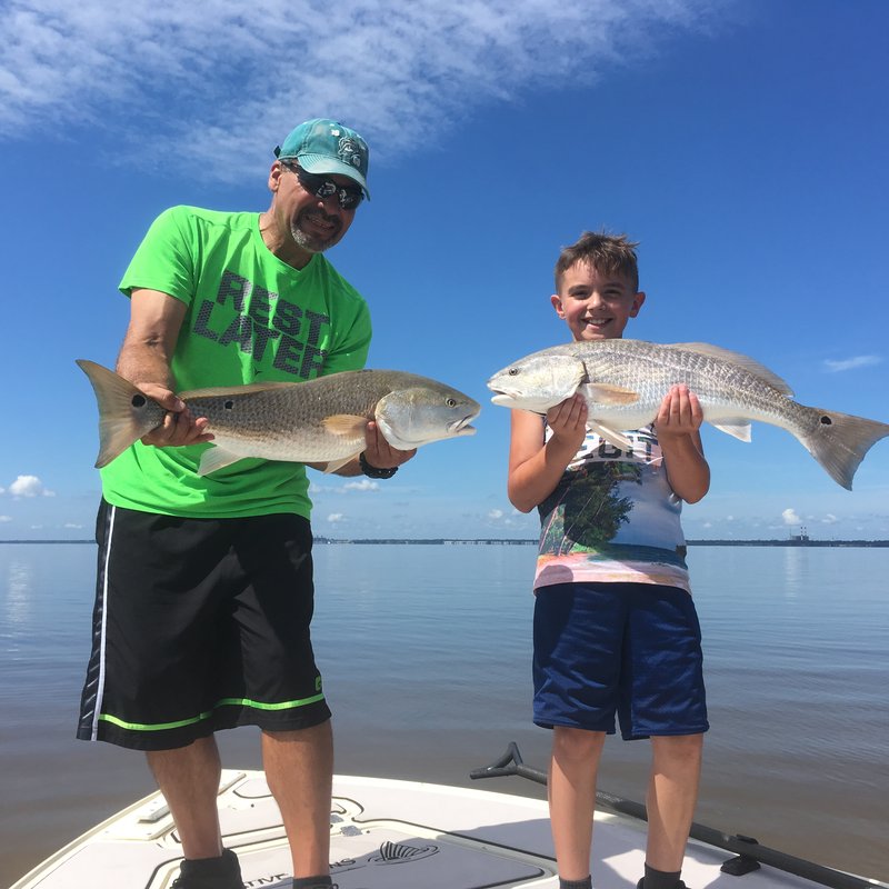 Angler sight-casting from the bow of a flats skiff on a New Smyrna Beach charter